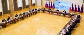 Posiedzenie Rady KSAP w sali im. Anny Walentynowicz w gmachu KPRM; widok z galerii dla gości - przy stole konferencyjnym ustawionym w podkowę siedzą członkowie Rady, w tle ekran elektroniczny z logo 30-lecia KSAP oraz flagi Polski i Unii Europejskiej