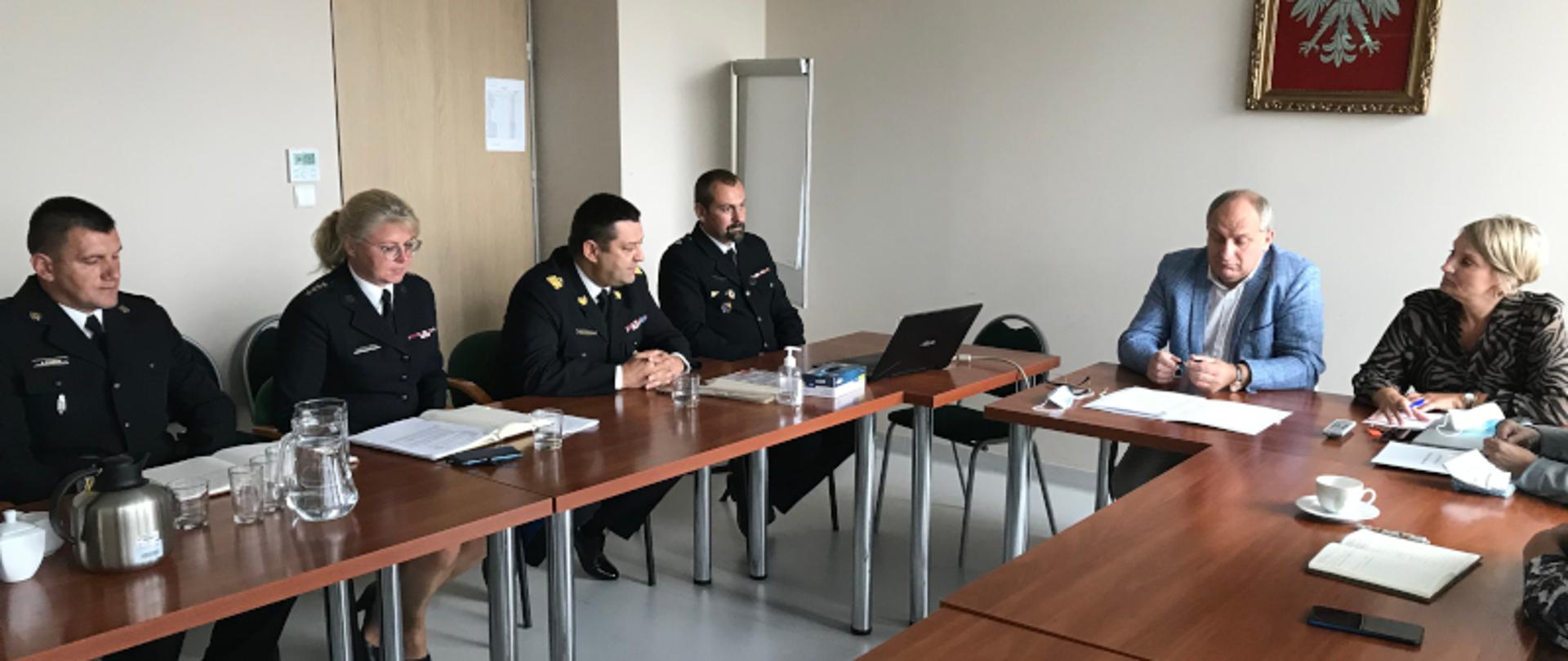 przy stole po prawej stronie zdjęcia przedstawiciele Kuratorium Oświaty, na środku Wicekurator Oświaty Jacek Szczotka, po lewej stronie Śląski Komendant Wojewódzki nadbryg. Jacek Kleszczewski oraz reprezentacja Komendy Wojewódzkiej Państwowej Straży Pożarnej w Katowicach 