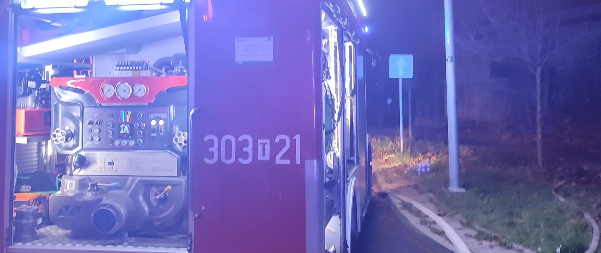 Zdjęcie przedstawia samochód gaśniczy z podłączona linią gaśniczą podczas działań w budynku przy ulicy Wojska Polskiego w Kielcach.