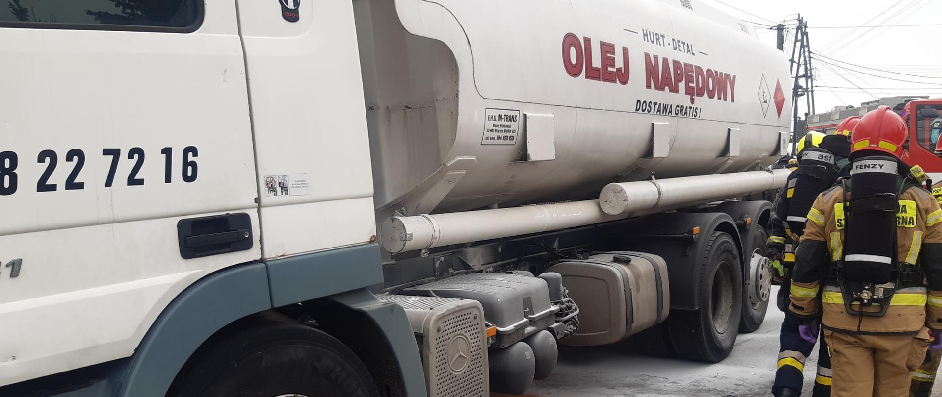 Na zdjęciu widoczna cysterna oraz strażacy w ubraniach specjalnych