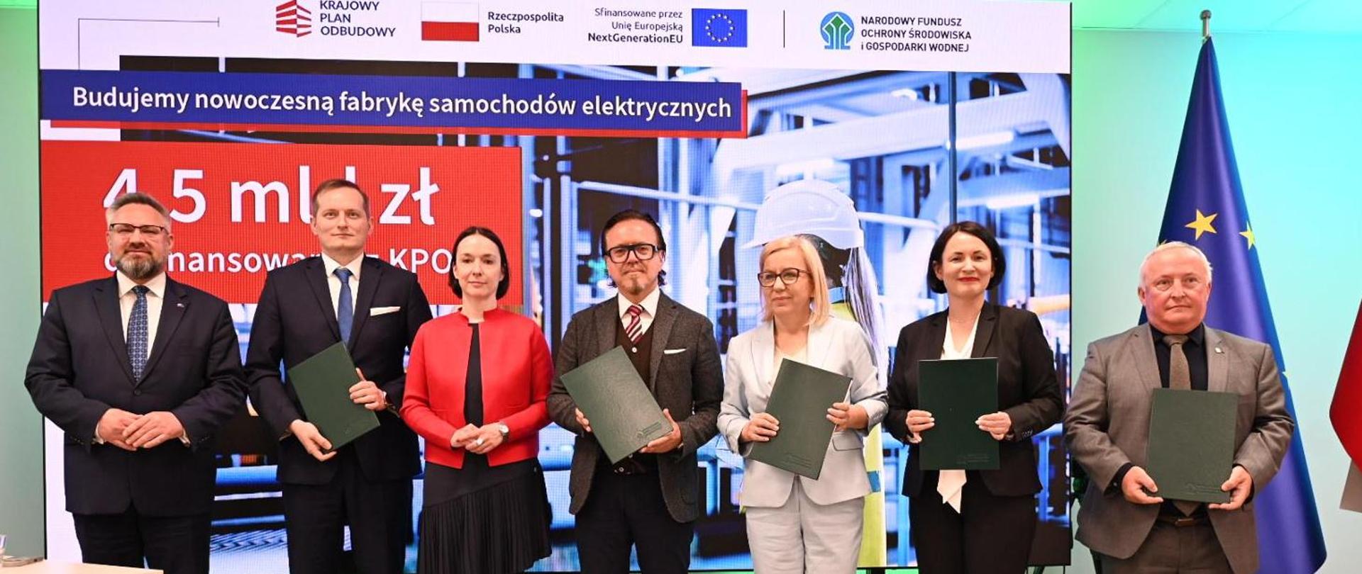 Minister of Climate and Environment Paulina Hennig-Kloska during the ceremony finalising the PLN 4.5 billion investment agreement from the National Recovery and Resilience Plan for the construction of the Polish Electromobility Hub in Jaworzno. The photo shows seven people posing: three women and four men. The Minister is fourth in line.