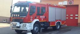 Widok na nowy samochód ratowniczo-gaśniczy dla Ochotniczej Straży Pożarnej w Rudce na tle strażnicy.