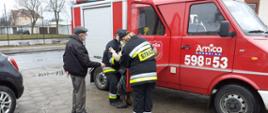 Widać samochód strażacki i osoby wysiadające