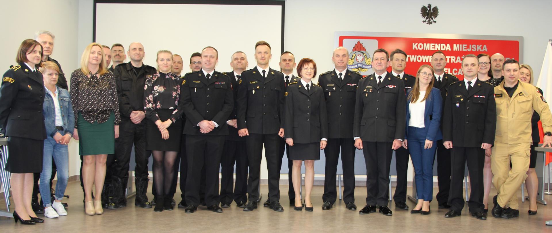 Na zdjęciu przedstawiono zgromadzonych współpracowników odchodzącego naczelnika Wydziału Kwatermistrzowsko-Technicznego z komendy miejskiej Państwowej Straży Pożarnej w Kielcach.