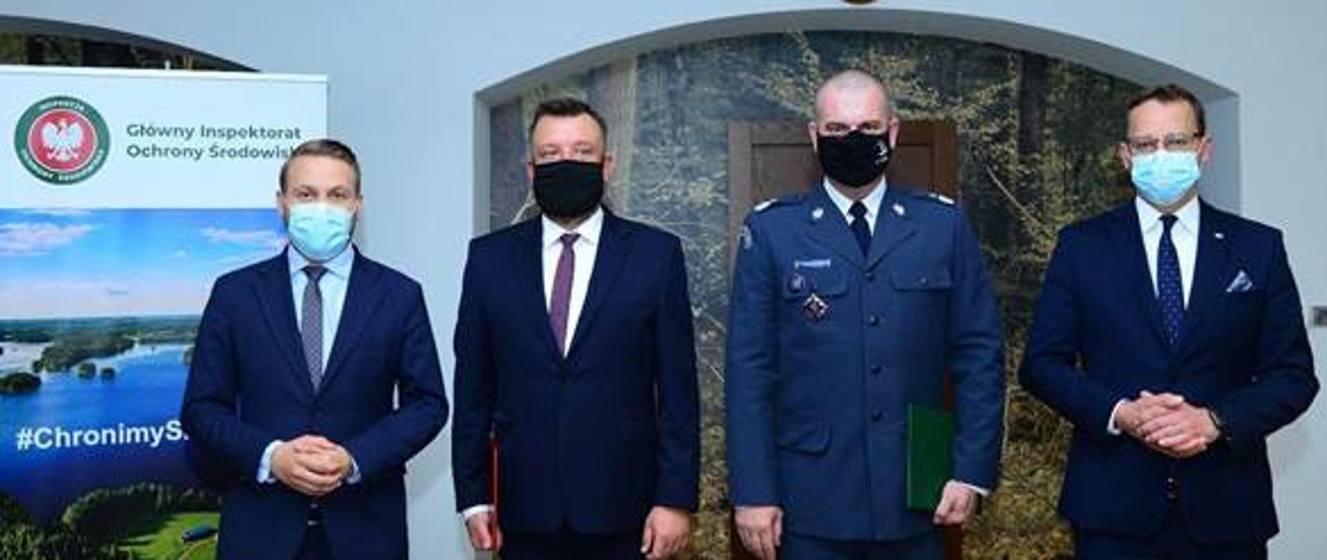 Czterech mężczyzn pozujących na tle drzwi.