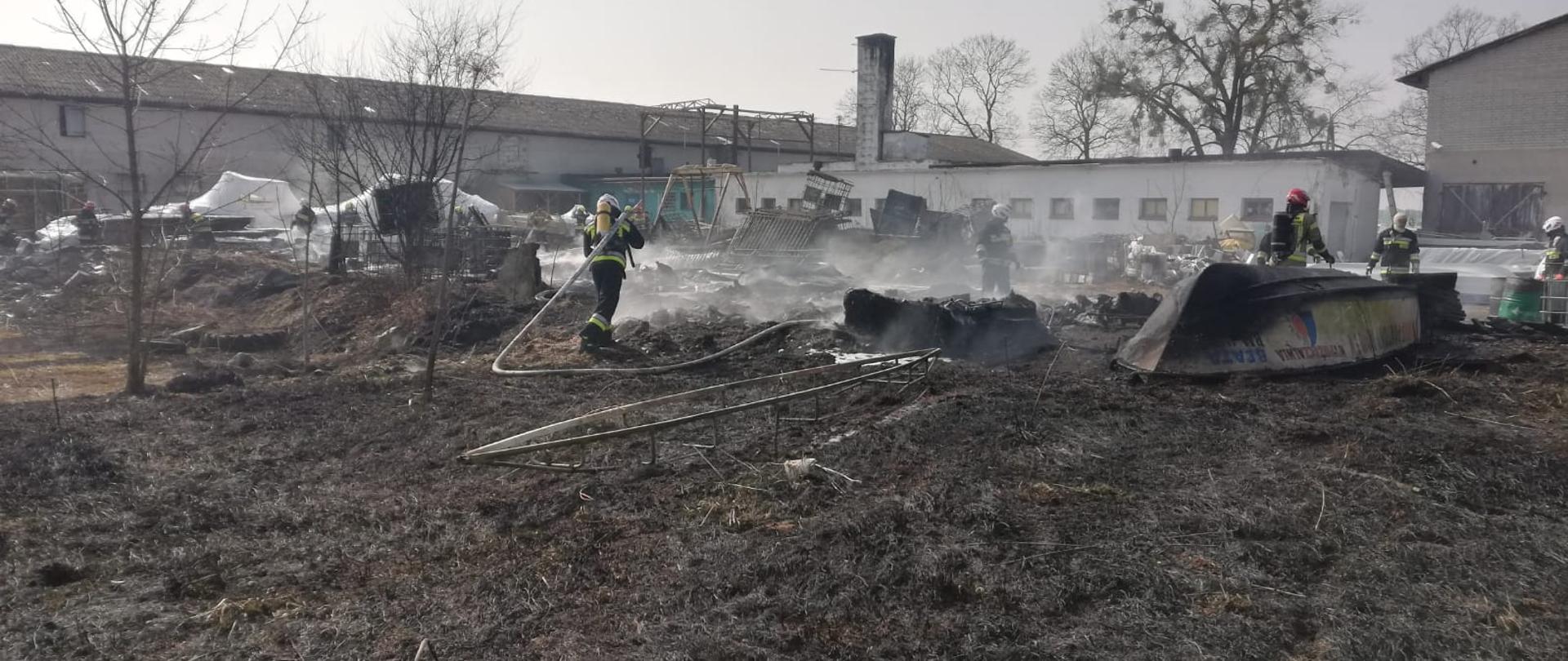 widać działania ratowniczo-gaśnicze prowadzone przez strażaków, spalone łodzie