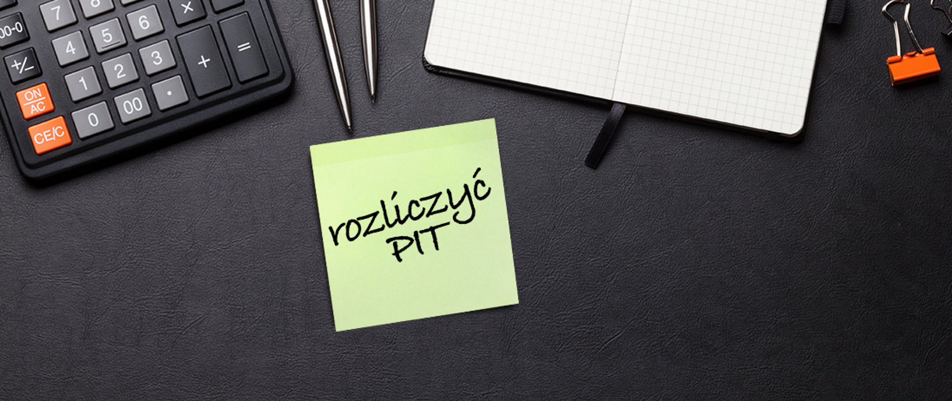 Baner z napisem: Rozliczyć PIT. W tle kalkulator, kartka papieru i długopis.