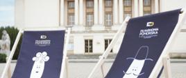 na tle budynku Filharmonii Pomorskiej dwa niebieskie leżaki