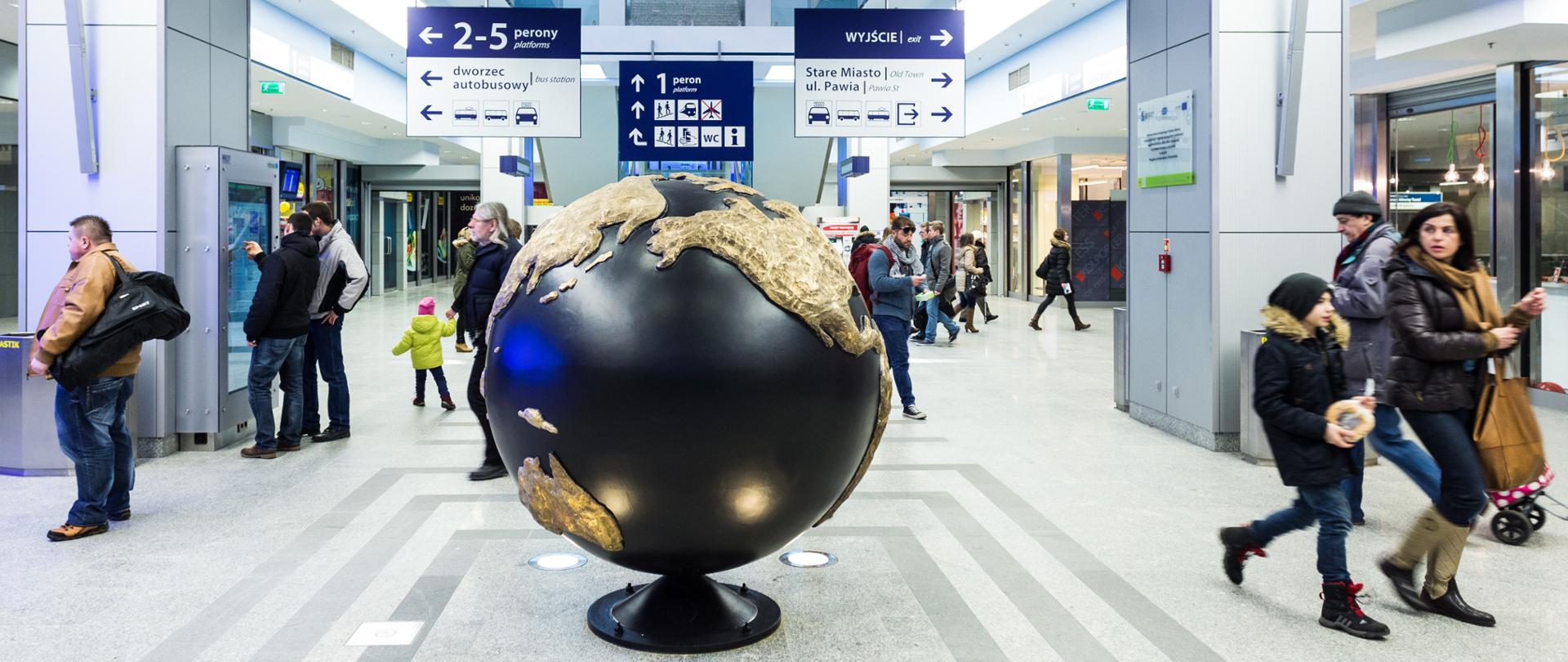podróżni we wnętrzu dworca kolejowego Kraków Główny zintegrowanego z miejskim transportem publicznym - inwestycja dofinansowana z Funduszy Europejskich