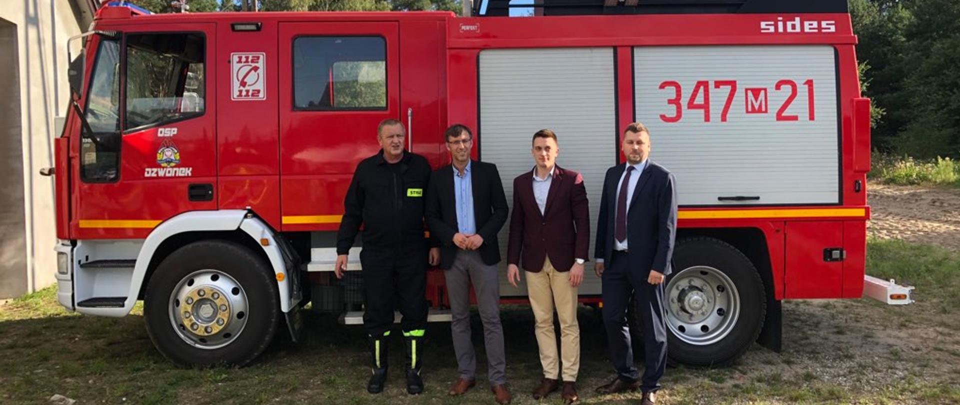 Na zdjęciu widać czterech mężczyzn przed samochodem Ochotniczej Straży Pożarnej