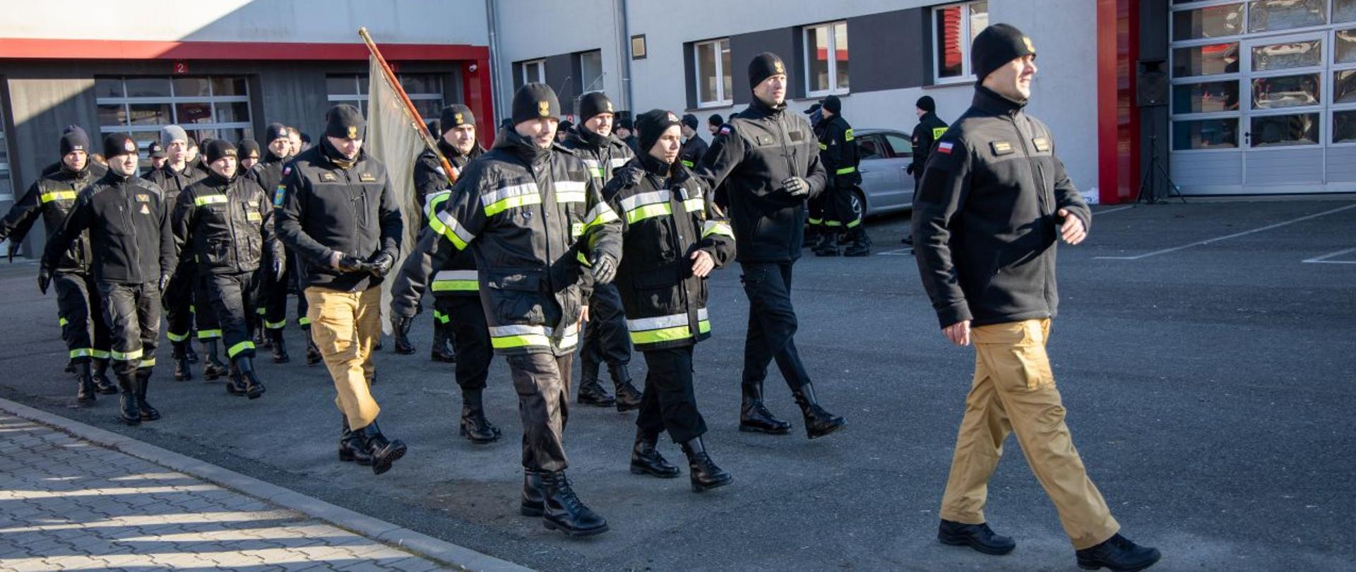Szkolenie kompanii reprezentacyjnej KW PSP w Opolu - ćwiczenie przemarszu przez plac. Strażacy PSP w umundurowaniu służbowym, sztabowym i koszarowym w ramach kompanii reprezentacyjnej, pocztu flagowego, pocztu sztandarowego, ćwiczą maszerowanie po placu KW PSP w Opolu.