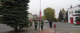 strażacy podnoszą flagę państwową 