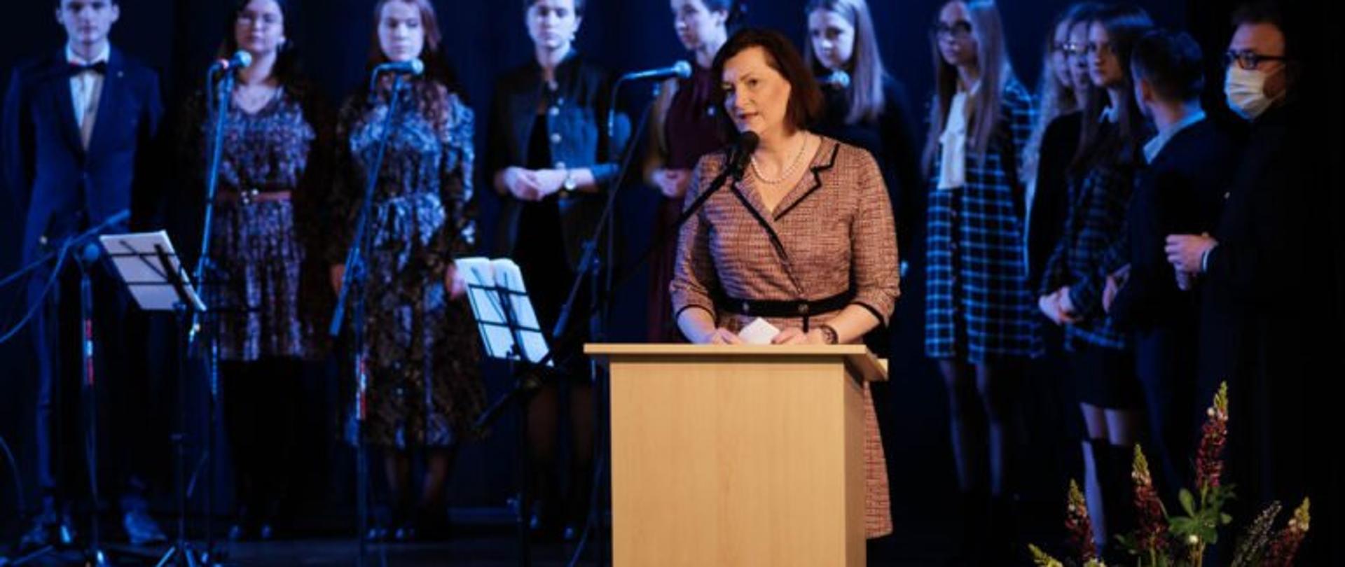 Wojewoda podkarpacki Ewa Leniart przemawia podczas spotkania Katolickiego Stowarzyszenia Młodzieży w Rzeszowie. Stoi przy mównicy, za nią znajduje się zespół muzyczny. 