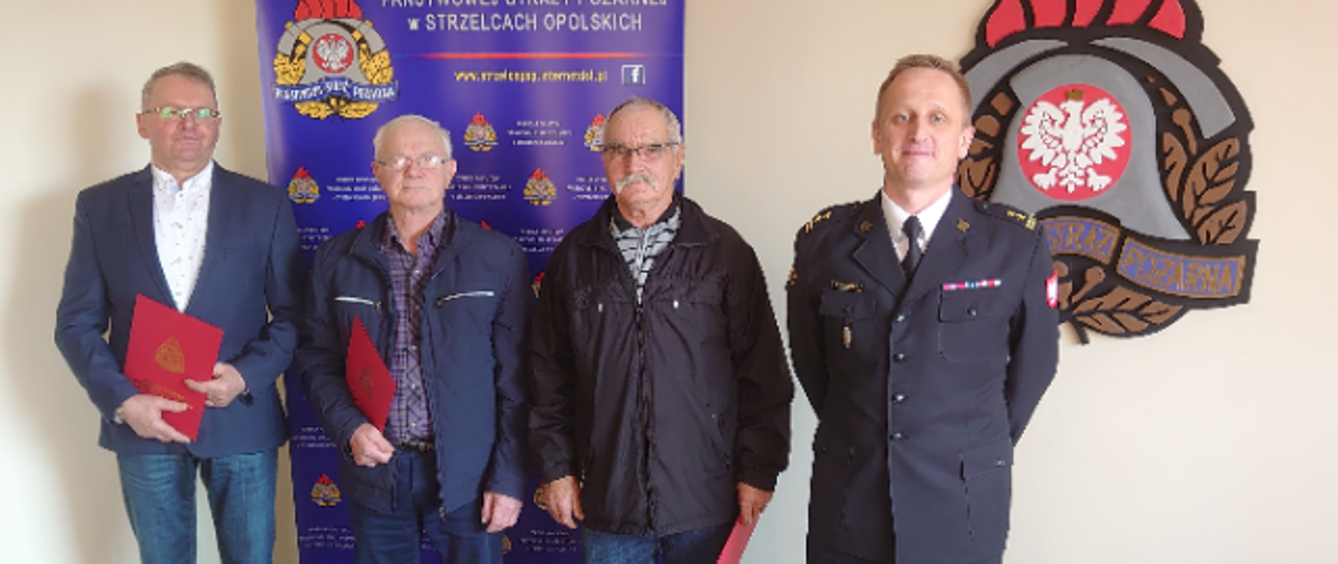 Na zdjęciu znajdują się cztery osoby wśród nich strażak w mundurze