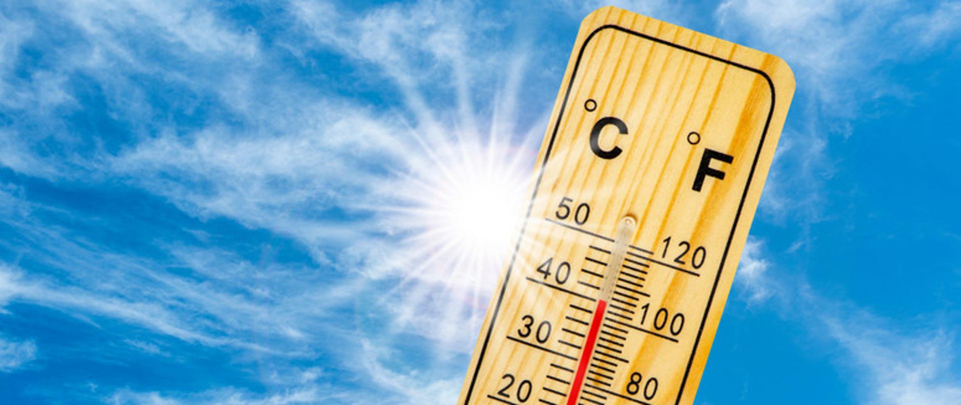 Zdjęcie przedstawia termometr rtęciowy na tle błękitnego nieba