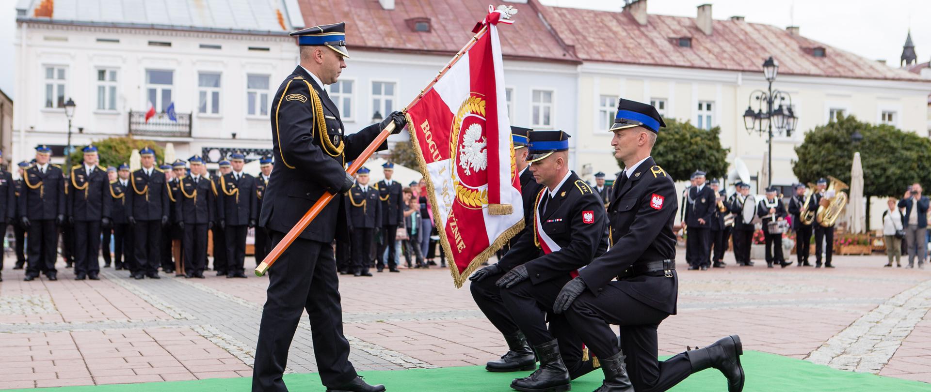 Moment przekazania nowego sztandaru. KP PSP przekazuje sztandar pocztowi sztandarowemu.
