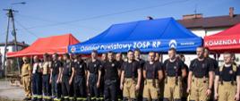 grypa kilkudziesięciu druhów osp stoi w dwuszeregu podczas odprawy z organizatorami ćwiczeń