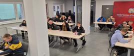 Druhny i druhowie piszą egzamin teoretyczny na sali szkoleniowej w Komendzie Powiatowej Państwowej Straży Pożarnej w Człuchowie. 