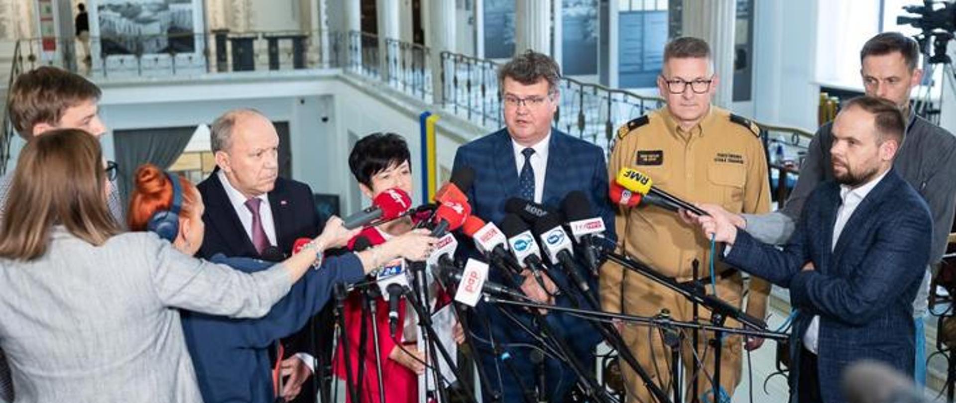 Na zdjęciu widać zastępcę komendanta głównego wraz z ministrem oraz dziennikarzami w sejmie