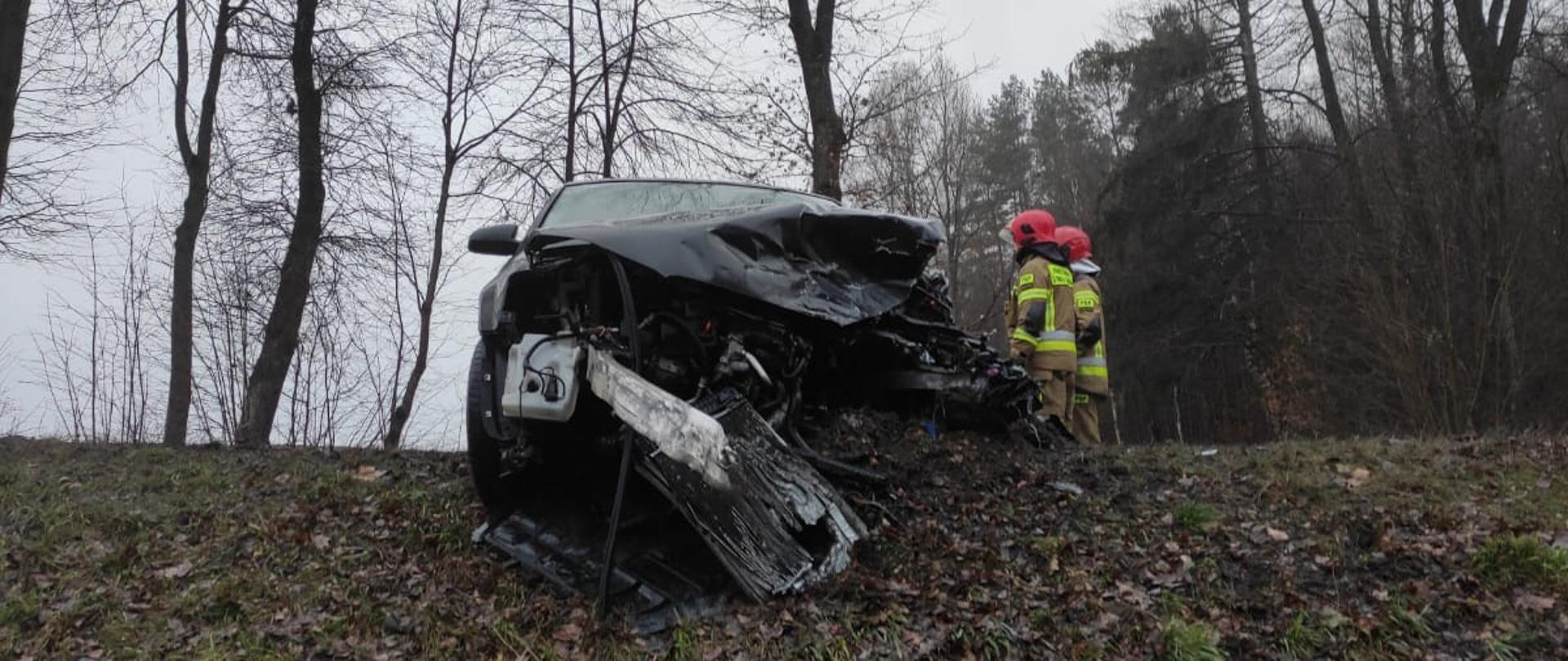 Uszkodzony przód pojazdu audi a3 oraz dwóch strażaków PSP