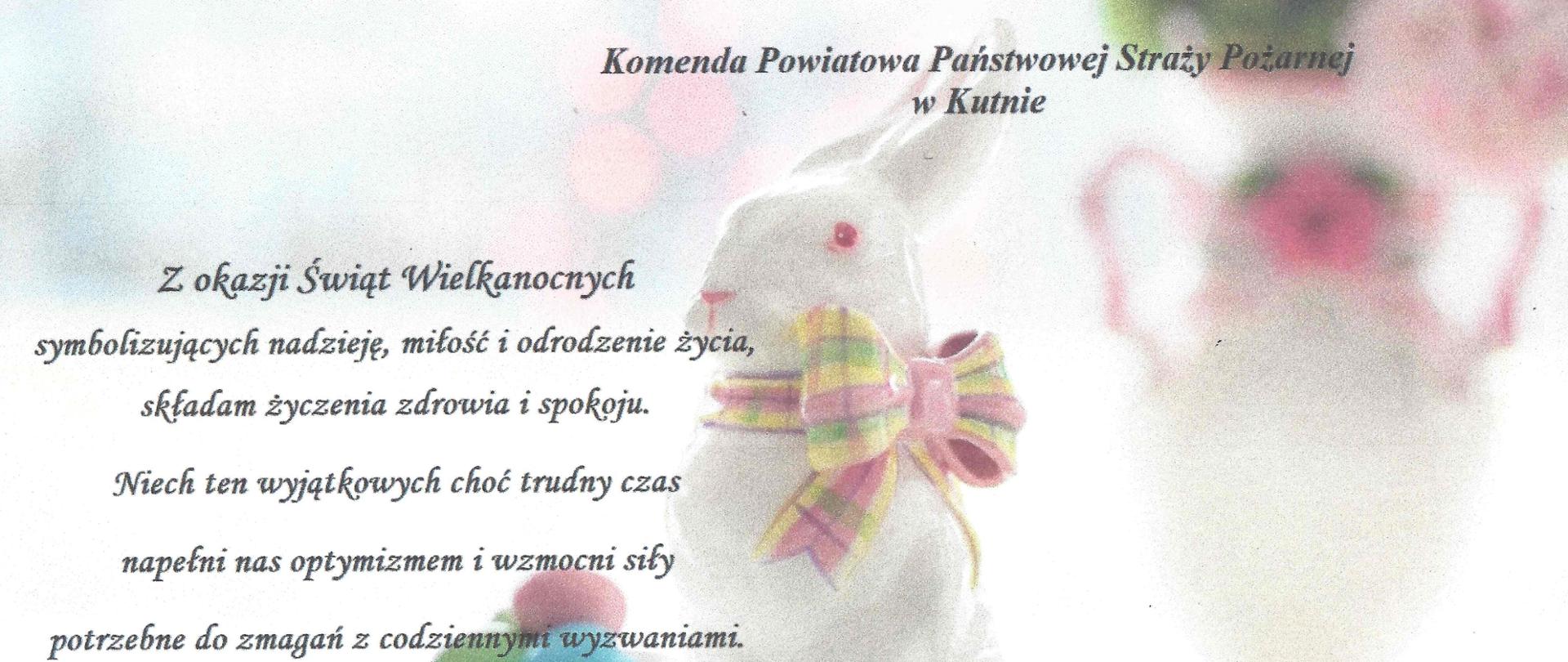 Życzenia wielkanocne na tle białego zajączka z kolorową kokardą na szyi. Dookoła zajączka leżą jajka malowane w kolorach niebieskim, żółtym, różowym i zielonym.