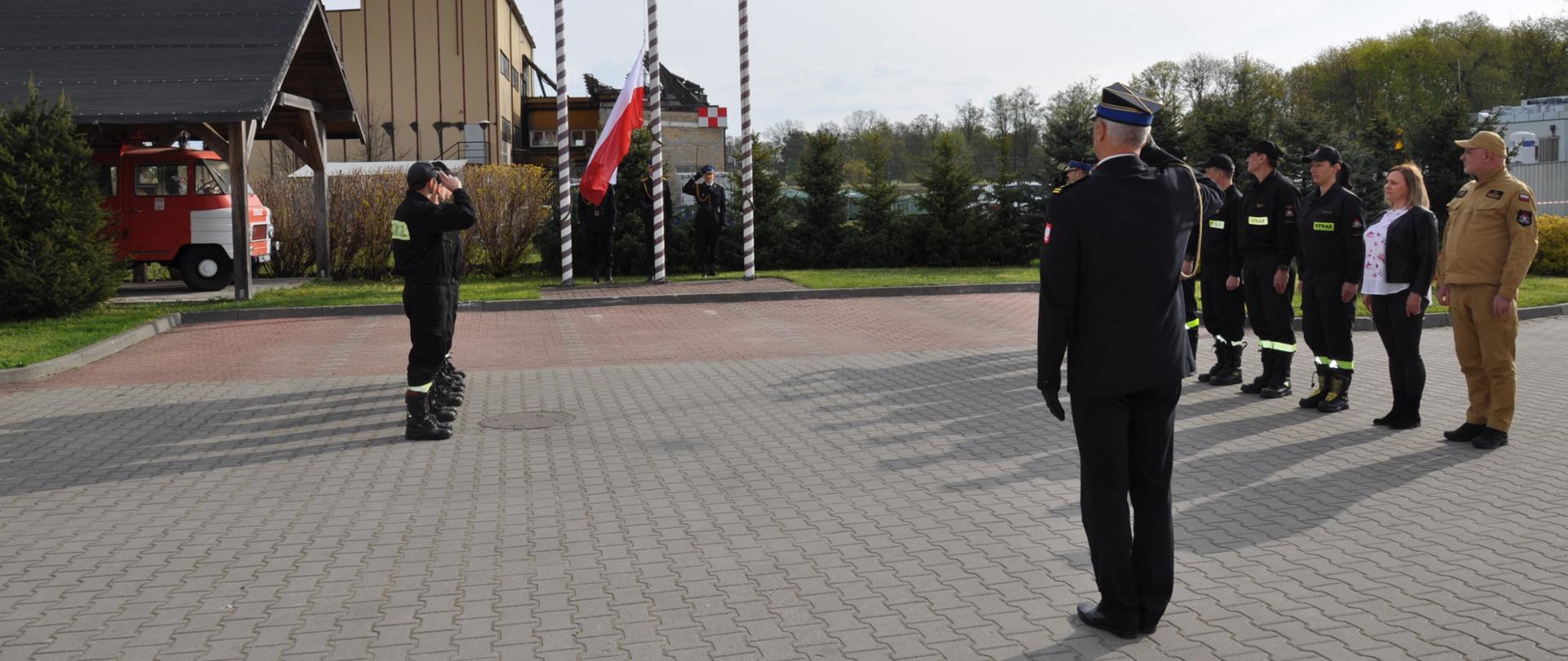 Strażacy oraz pracownicy cywilni podczas uroczystego apelu z okazji Święta Flagi RP