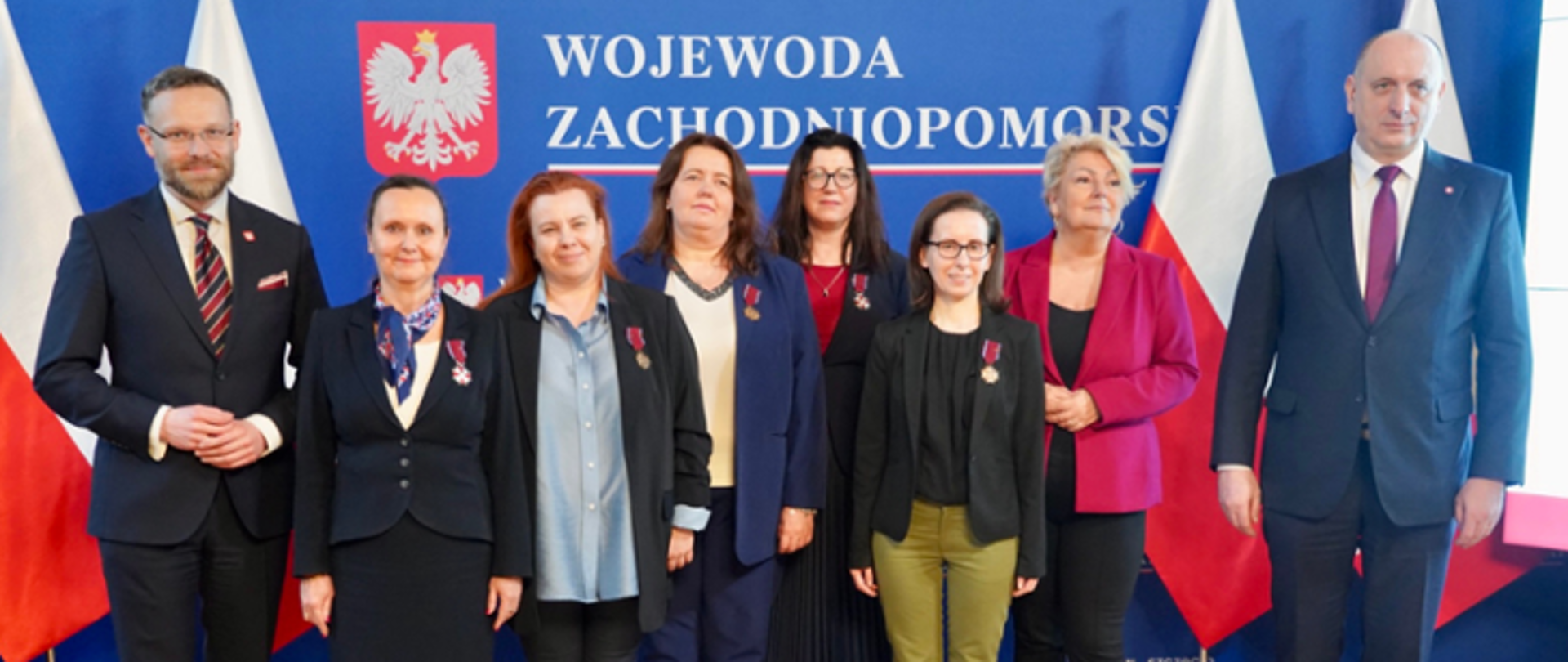 Grafika przedstawia zdjęcie grupowe osób odznaczonych za zasługi w walce z pandemią