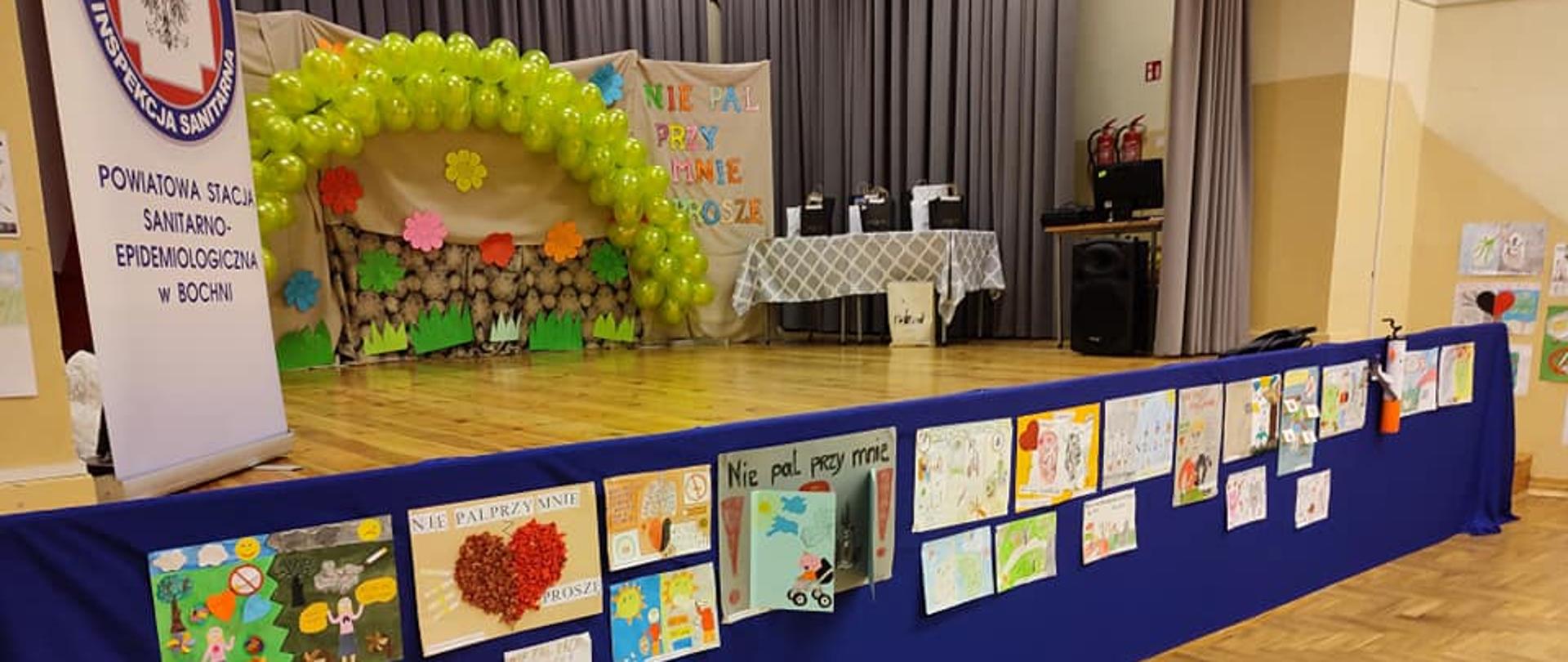 Scena, prace plastyczne dotyczące palenia papierosów, balony, logo Państwowej Inspekcji Sanitarnej