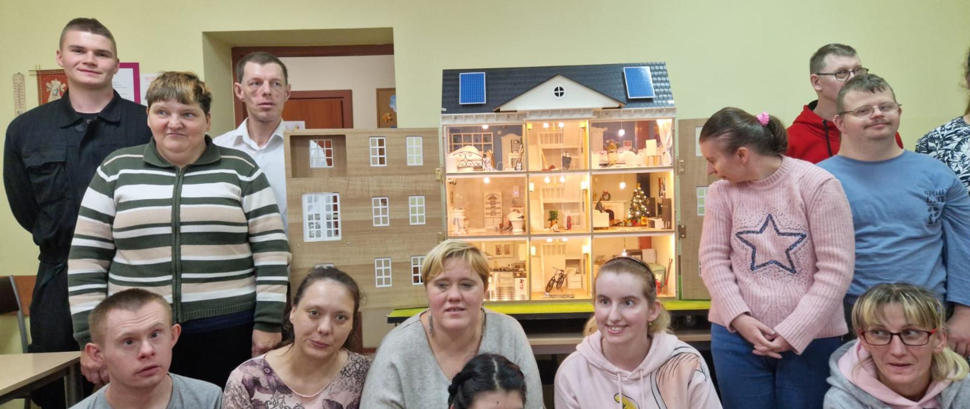 Zdjęcie przedstawia funkcjonariusza PSP oraz uczestników prewencji społecznej.