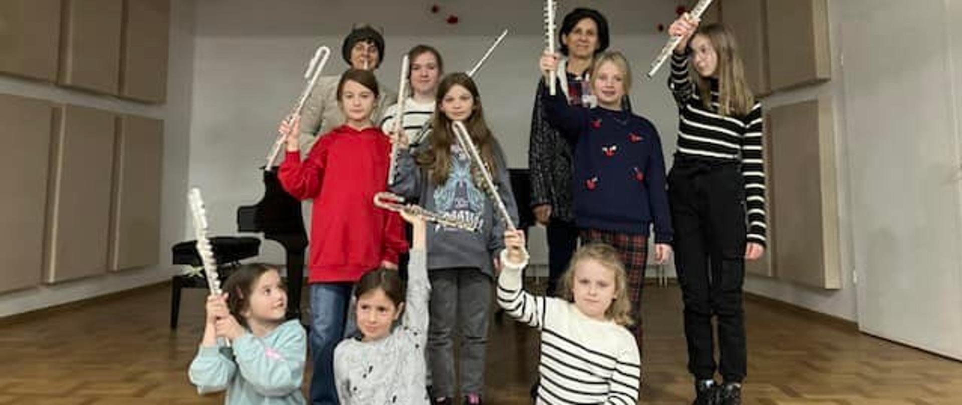 Uczniowie klasy fletu stojący na scenie podczas warsztatów z panią Ewą Biały. 