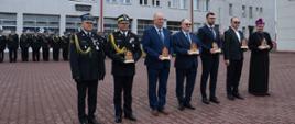 Zdjęcie przedstawia osoby odznaczone w tle pododdział kompanii honorowej na plac uroczystości
