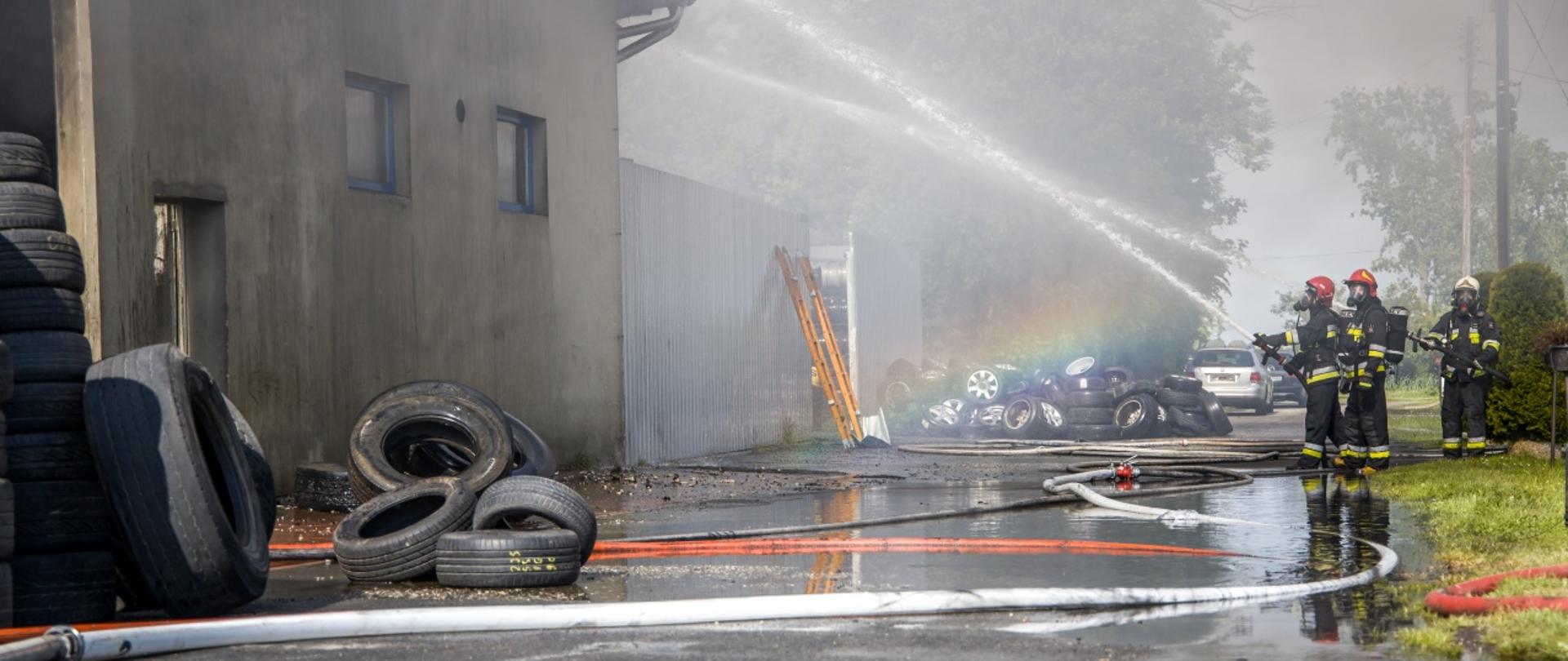 Zdjęcie przedstawia działania strażaków PSP i OSP przy pożarze warsztatu wulkanizacyjnego wraz z częścią magazynową.