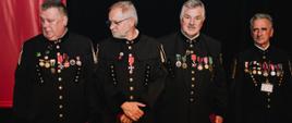Osoby uhonorowane orderami i odznaczeniami państwowymi (czterech stojących mężczyzn w galowych mundurach górniczych, do których przypięte są ordery i odznaczenia)