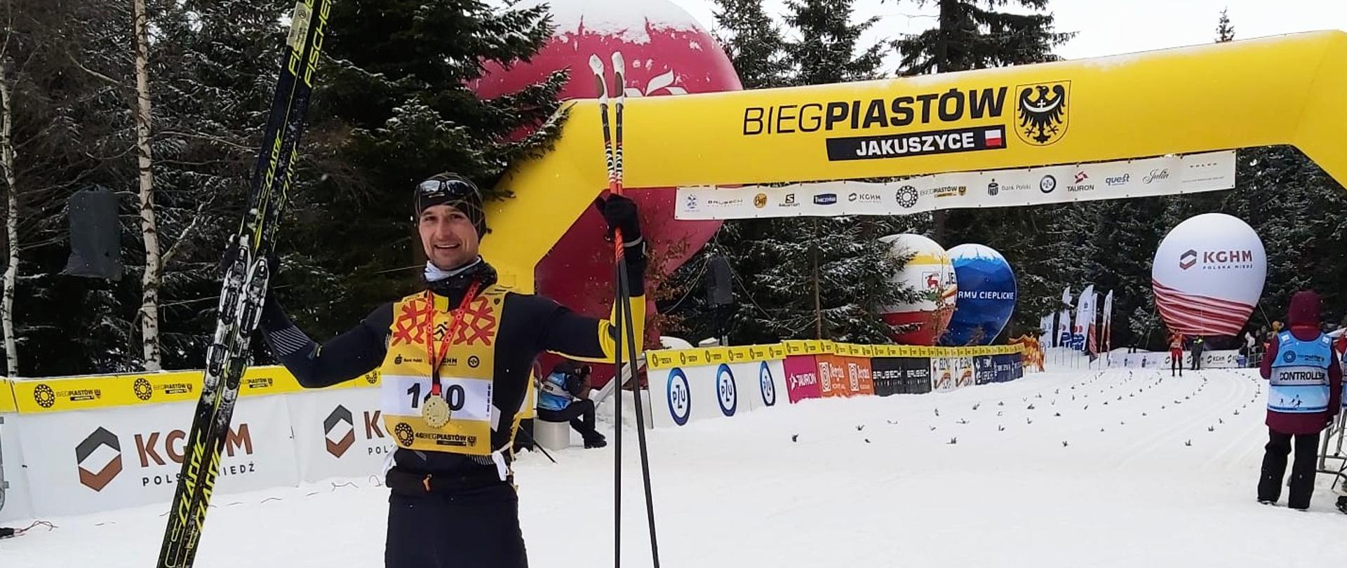 Strażak z KP PSP Starachowice z medalem za IV miejsce z nartami biegowymi i kijkami w rękach