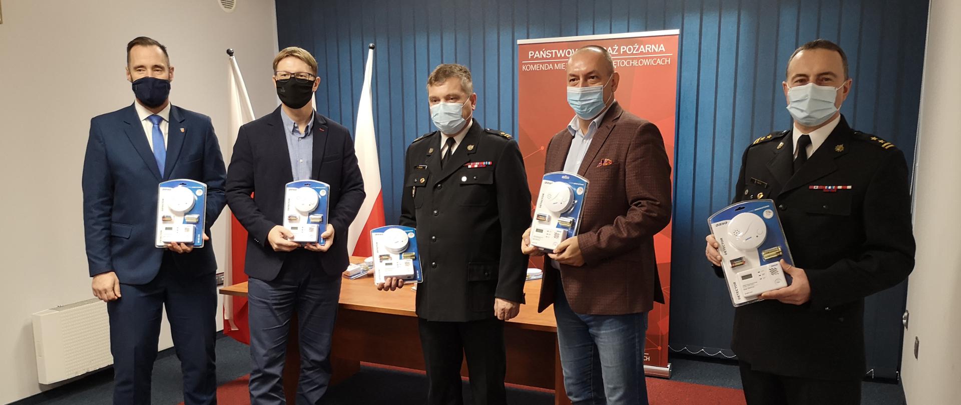 Na zdjęciu znajduje się 5 osób. Od lewej: zastępca Prezydenta Miasta, Prezydent Miasta, Prezes Miejskiego Przedsiębiorstwa Gospodarki Lokalowej, Zastępca Komendanta Miejskiego Państwowej Straży Pożarnej w Świętochłowicach, Dowódca Jednostki Ratowniczo-Gaśniczej.