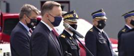 Promesy na zakup samochodów dla OSP z Mazowsza – na zdjęciu przemawia Prezydent RP Andrzej Duda. Jest w maseczce.