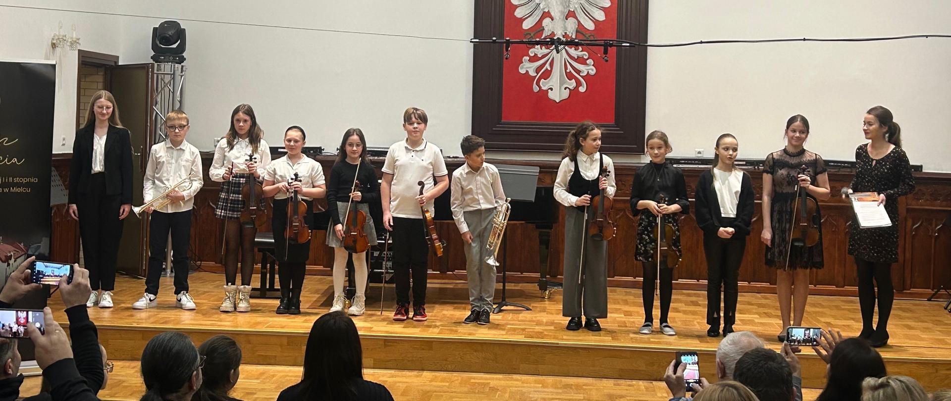 uczniowie klasy czwartej B cyklu sześcioletniego podczas koncertu klasowego w sali królewskiej PSM w Mielcu