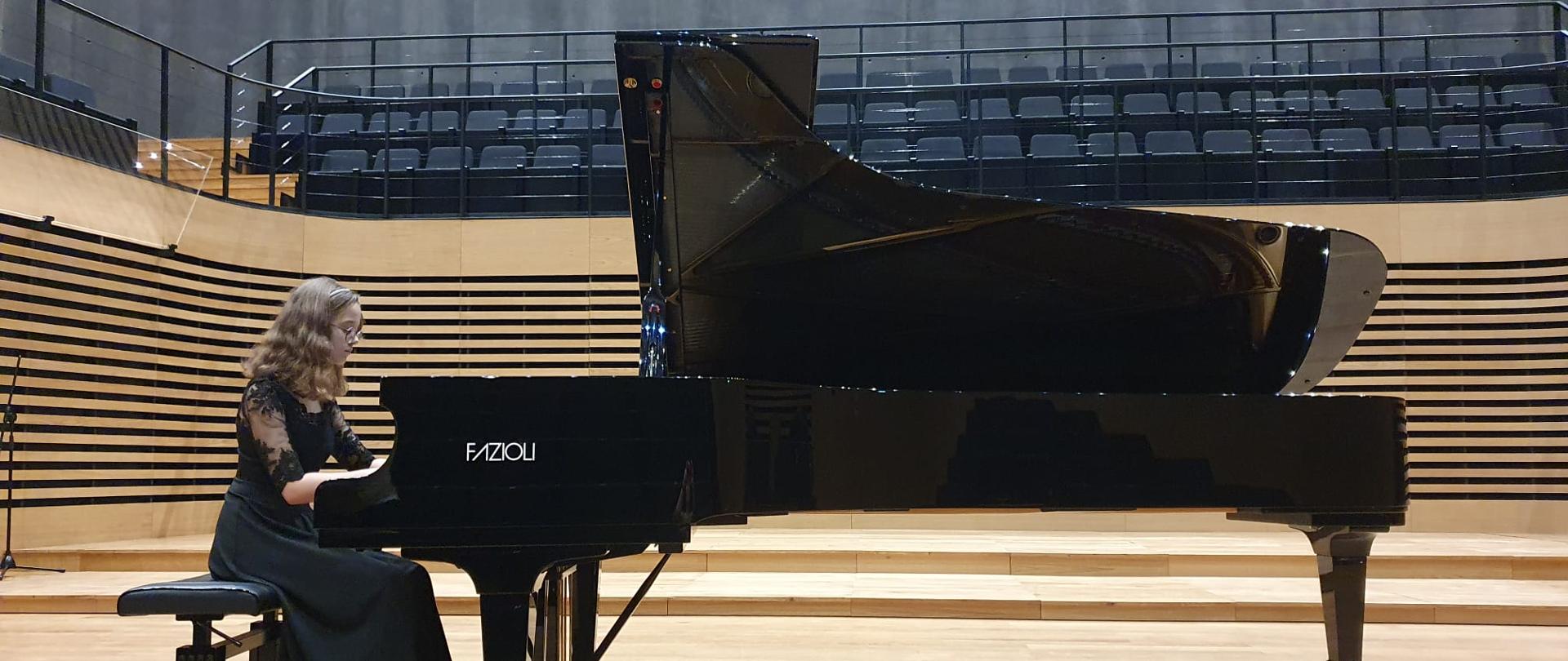 Uczennica grająca na fortepianie w sali koncertowej PSM w Jastrzębiu-Zdroju