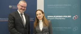 Minister funduszy i polityki regionalnej Katarzyna Pełczyńska-Nałęcz i Ambasador Szwajcarii w Polsce Fabrice Filliez, pani minister ściska dłoń z panem ambasadorem, za ich plecami baner MFiPR