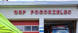 Z lewej siedzą zaproszeni goście, na wprost kapelan strażaków na tle jednostki OSP Pogorzelec