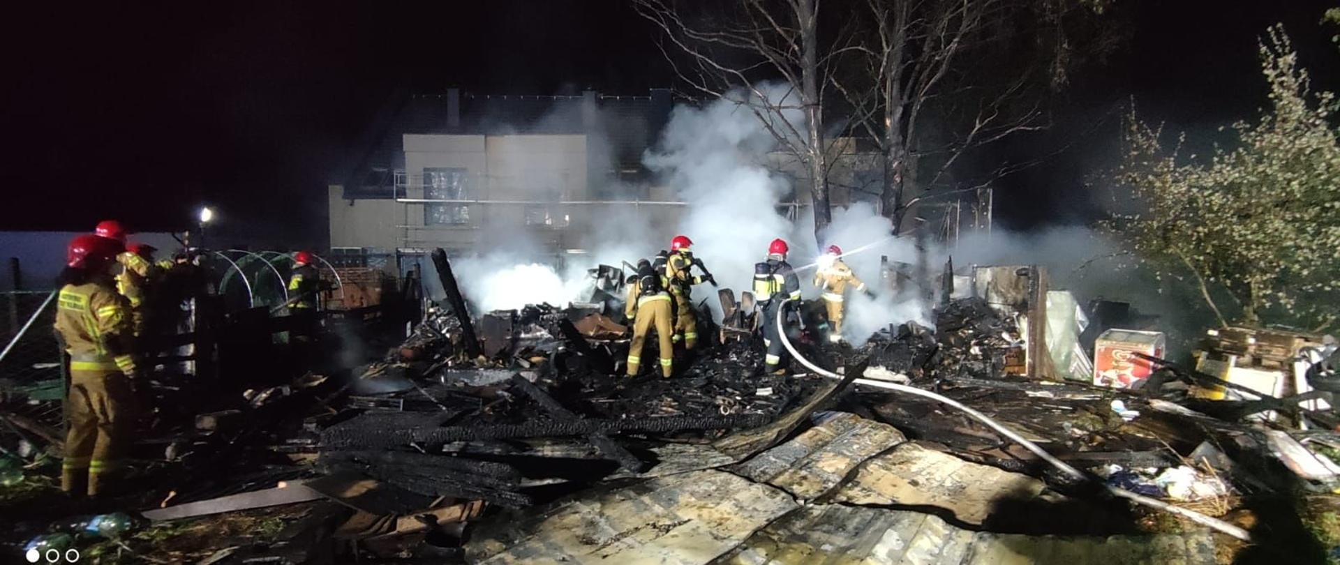 Zdjęcia przedstawiają strażaków w trakcie akcji gaśniczej altany. 