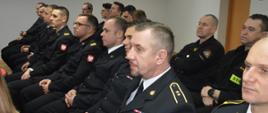 Narada roczna W świetlicy komendy powiatowej PSP w Rawiczu siedzą uczestnicy narady - funkcjonariusze komendy. Strażacy występuja w umundurowaniu wyjściowym i koszarowym. 