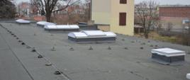 Dach budynku głównego budynku.. Na nim 5 nowych świetlików. W tle obiekty Zakładu Karnego w Rawiczu.