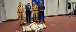 Strażacy oraz marszałek i dyrektor word stoją podczas przekazania płacht gaśniczych