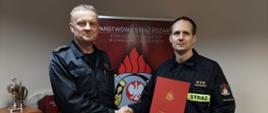 Zdjęcie przedstawia moment gratulacji i przekazania aktu mianowania na wyższe stanowisko służbowe.
