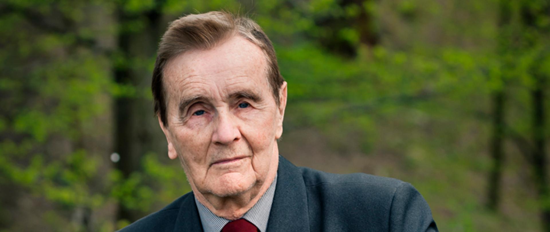 Zdjęcie przedstawiające Romualda Twardowskiego siedzącego na tle drzew