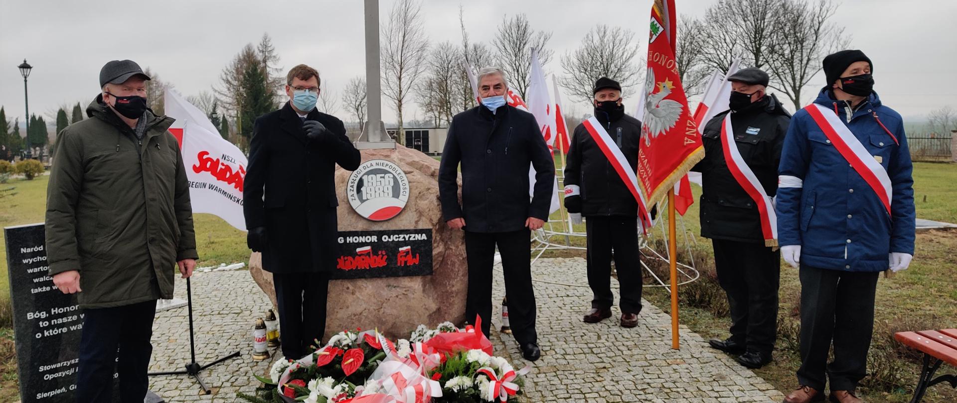 Wojewoda wraz z delegacjami i pocztem sztandarowym stoi przy pomniku