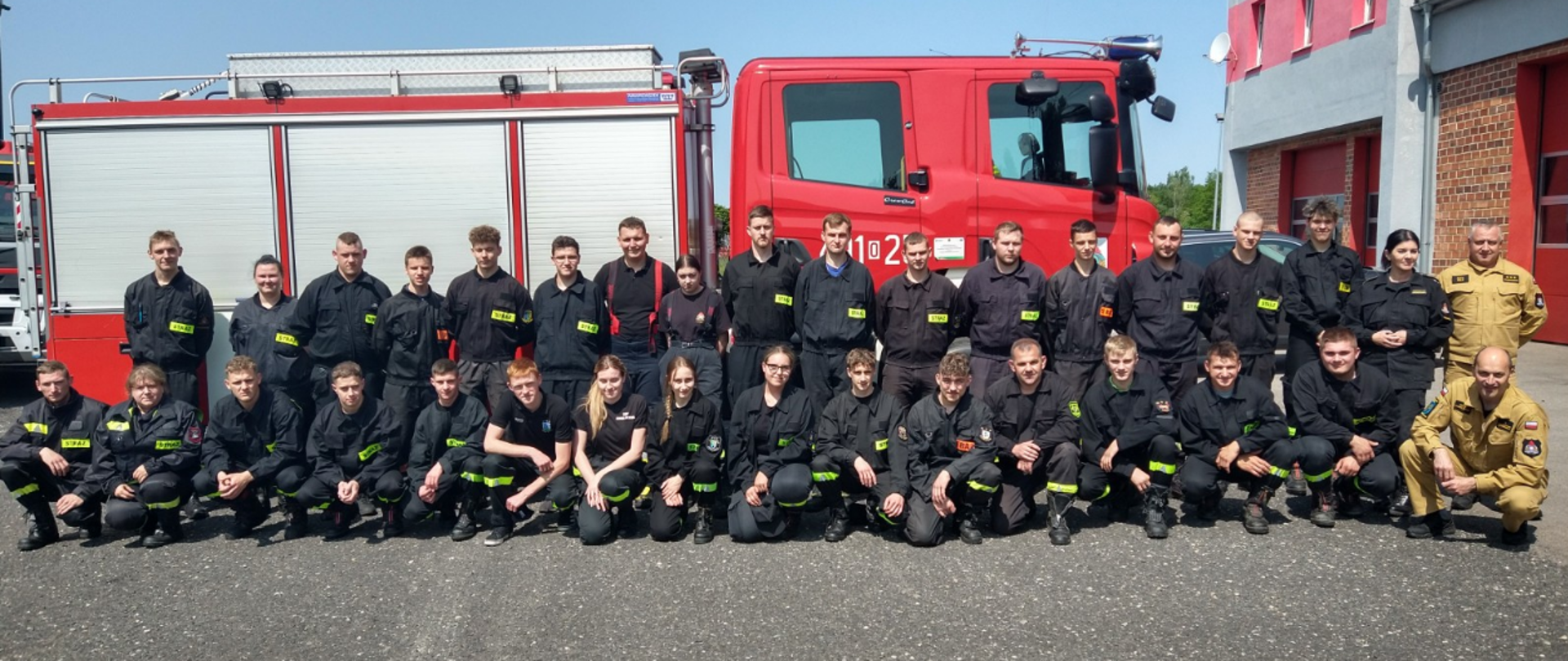 Na zdjęciu znajdują się uczestnicy szkolenia w ubraniach koszarowych na tle samochodu strażackiego