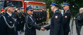 Komendanci obecni na uroczystości wręczają medale druhom z ochotniczej straży pożarnej