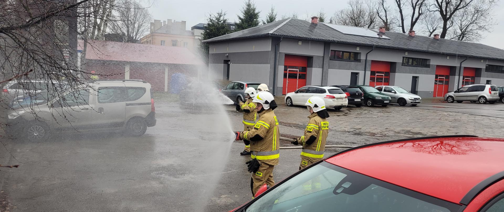 Ratownicy OSP podający prąd wody z linii gaśniczych
